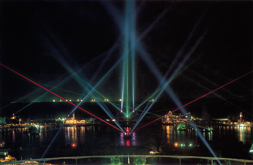 Laser beams fanning across the Epcot lagoon during Laserphonic Fantasy