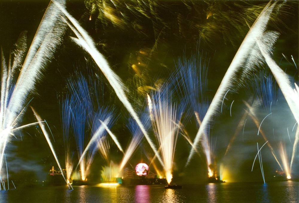 Fountains and fireworks rising from World Showcase Lagoon in the Celebration finale of Reflections of Earth